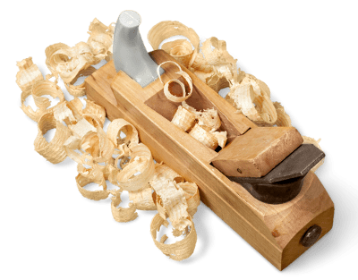Una pialla manuale in legno circondata da trucioli di legno, utilizzata per lisciare o modellare le superfici del legno durante la lavorazione artigiana legno per porte artigianali in legno.